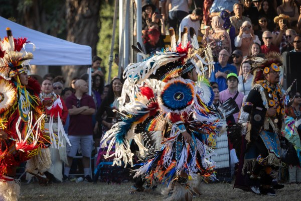 Powwow dancers in traditional Native American dress.
