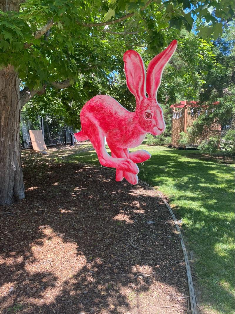 a pink rabbit sculpture in the middle of the frost grove