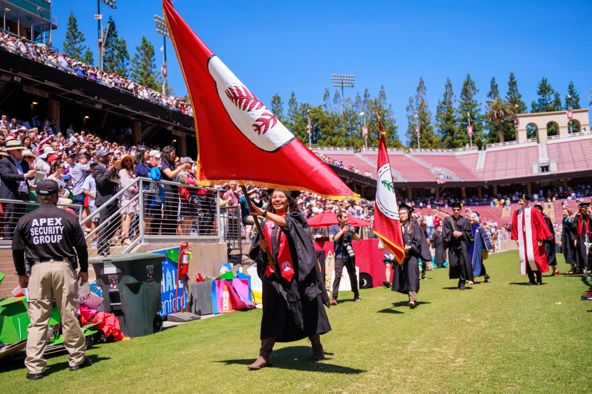 Student waving flag at Stanford commencement