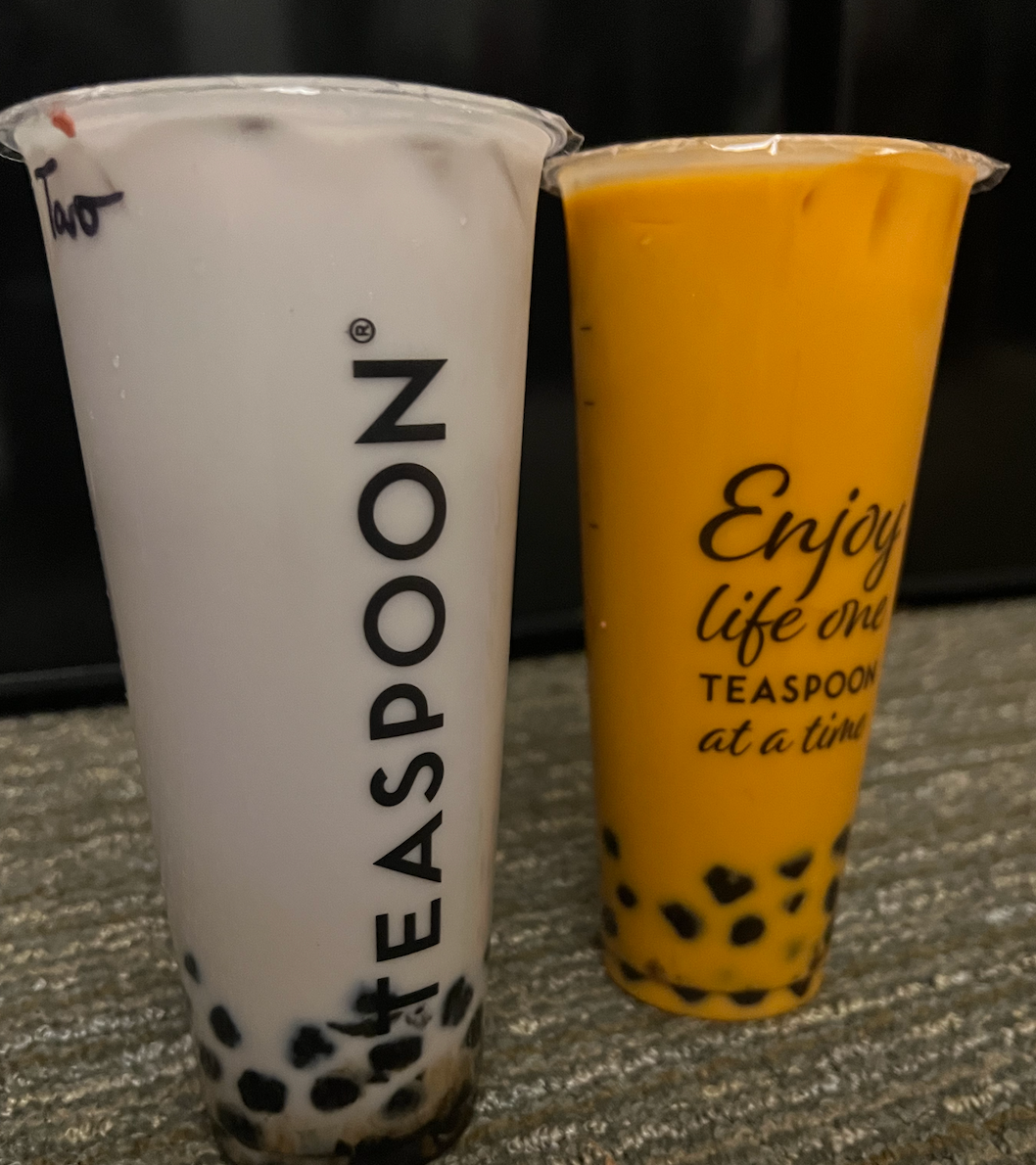 Two drinks from Teaspoon, one taro and one Thai, stand on a couch. 