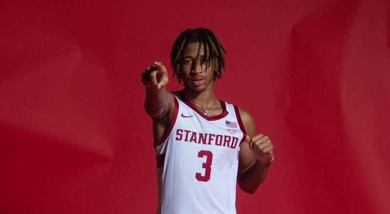 Kanaan Carlyle points toward the camera in a Stanford basketball jersey.