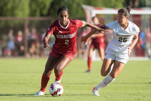 Naomi Girma '22 dribbles the ball past a defender in a game against Santa Clara in 2021. Girma, who  plays for US Women's National Team, is an example of the world class talent Stanford athletics draws in. (Photo: Jim Shorin/ISI Photos)