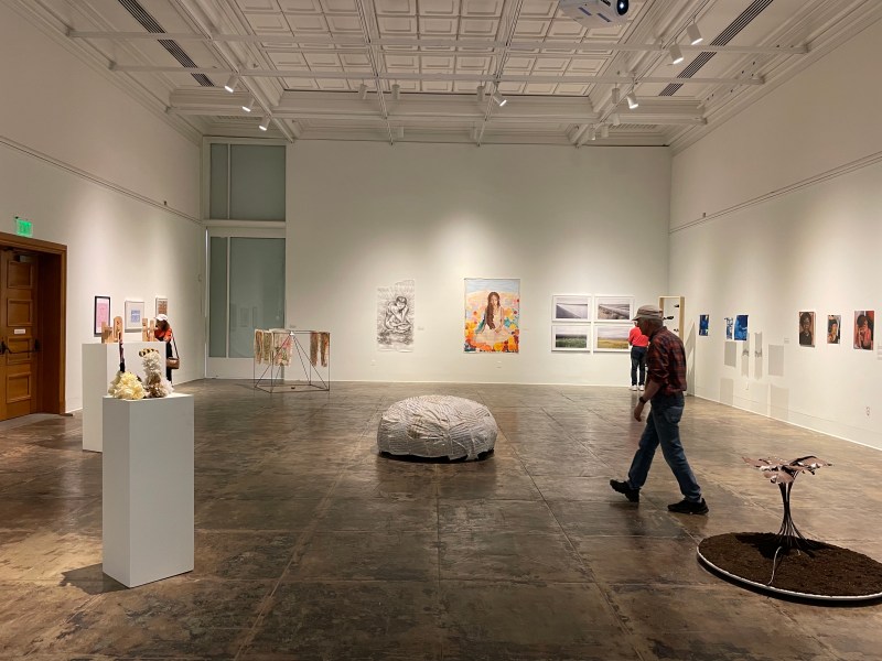 A bright, empty art gallery with a bean bag in the center.