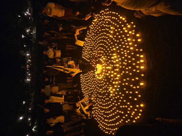 A gathering of students around a circle of candles.