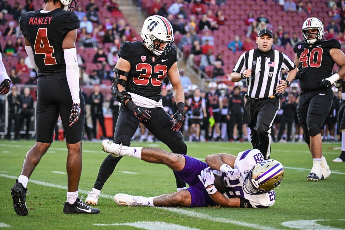 Stanford defender stands over Washington running back