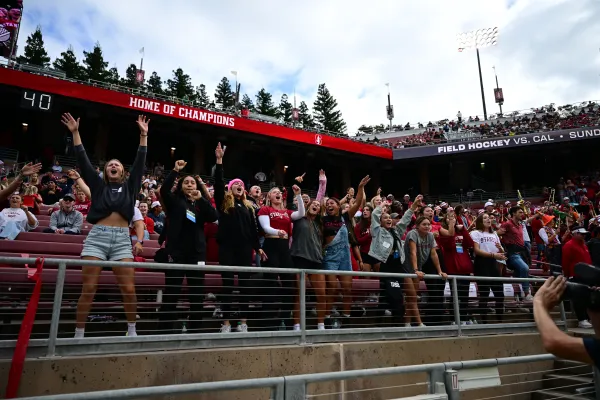 A photo of fans in the stands of the football stadium.