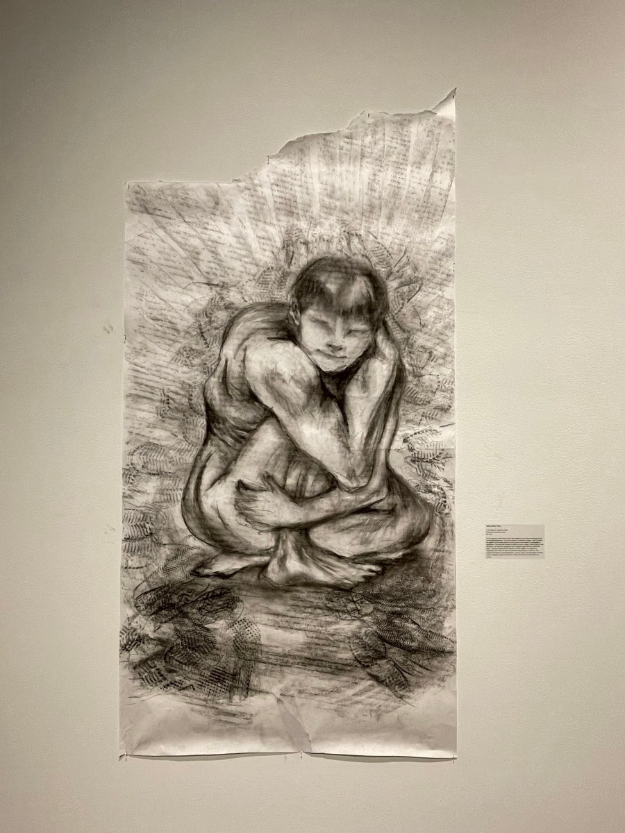 A charcoal drawing of a person curled into a ball.