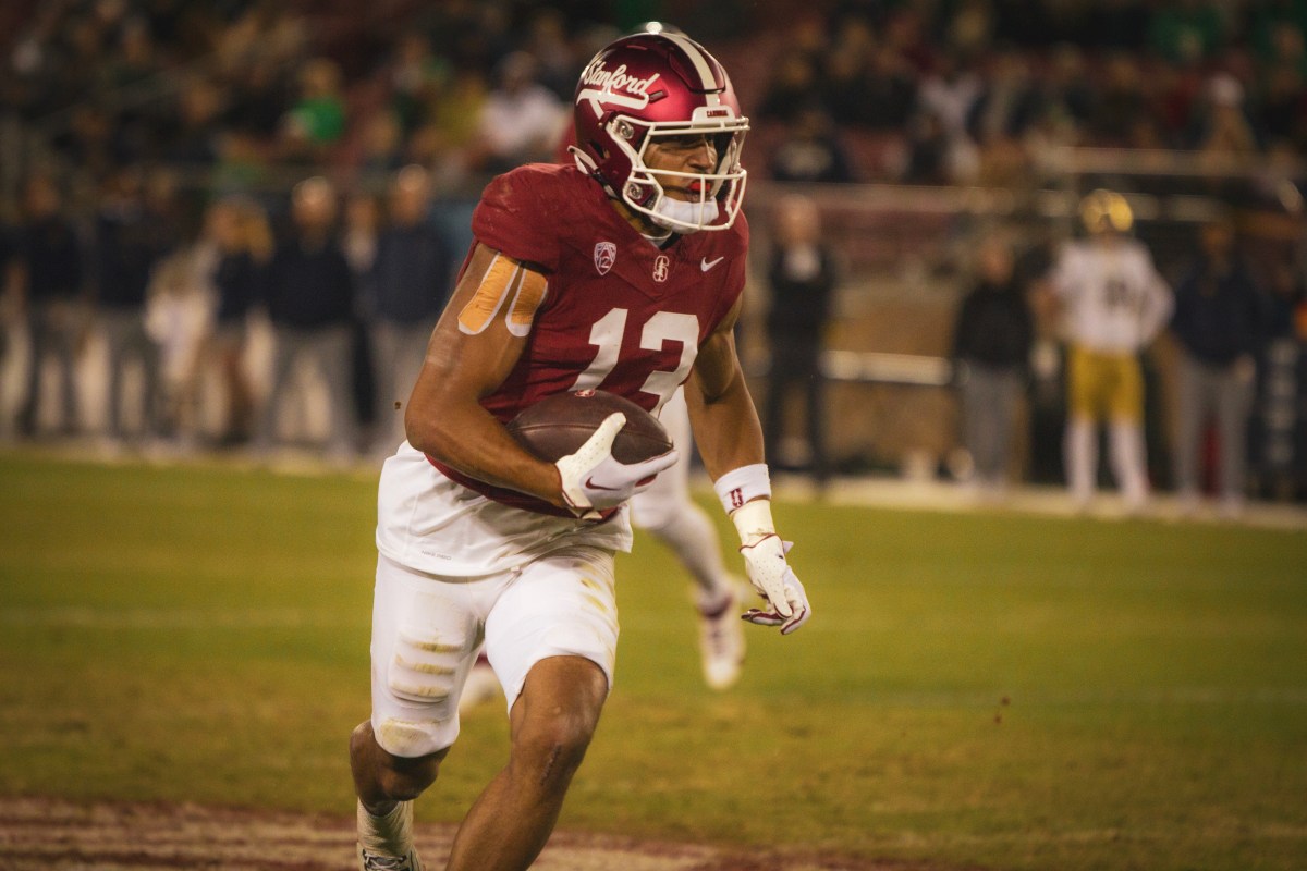 A Stanford player carries the ball on the field.