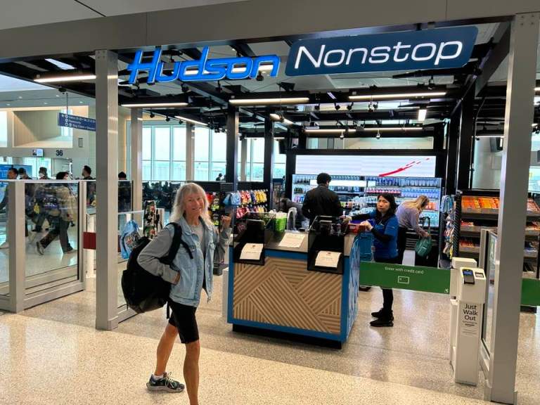 Woman in the airport posing in front of the Hudson store