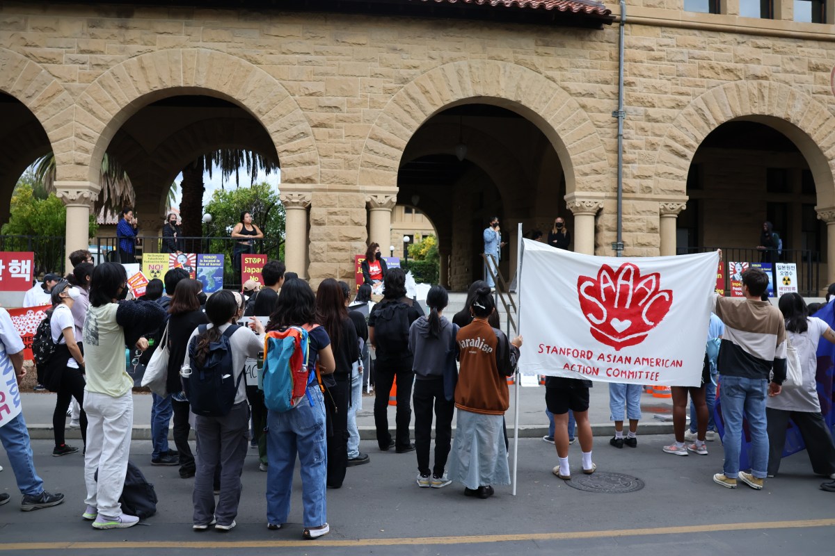 Protestors gathered outside Main Quad, carrying a banner for the Stanford Asian American Action Committee.