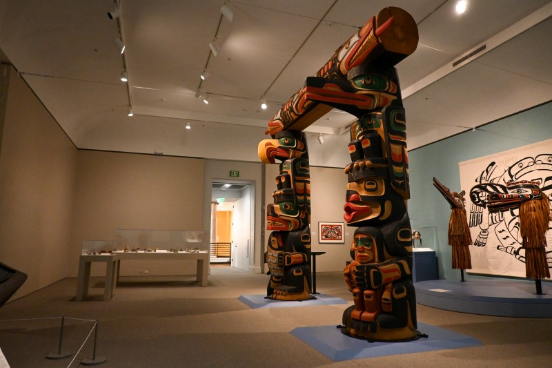 A rectangular arch constructed of painted wooden totems
