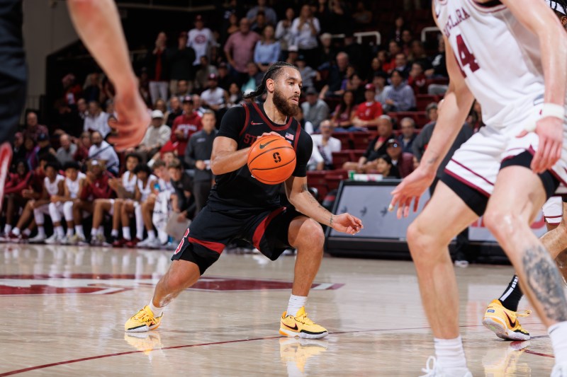 A Stanford player dribbles the ball at the top of the key.