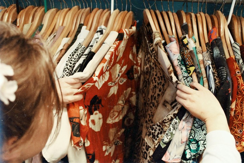 Woman searching in her closet full of clothes with prints