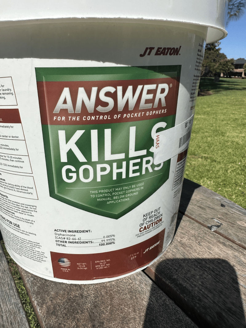 A bucket that reads "answer for the control of pocket gophers, kills gophers."