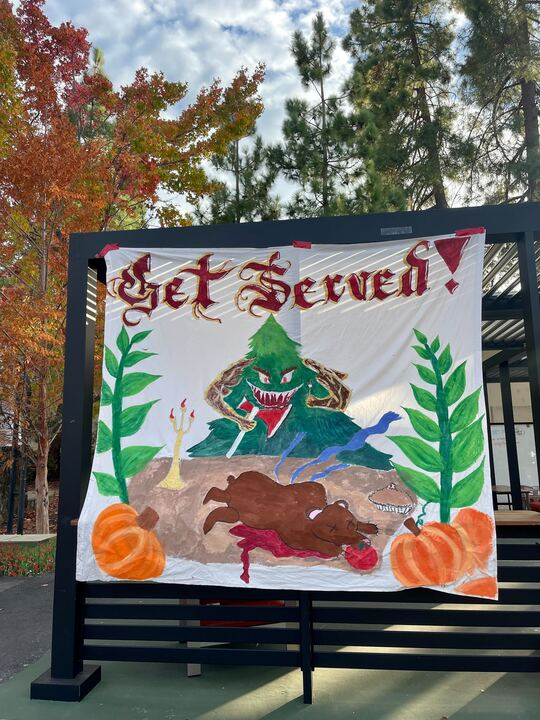 A banner that reads get served in white plaza with a depiction of a tree with an axe and a dead bear.