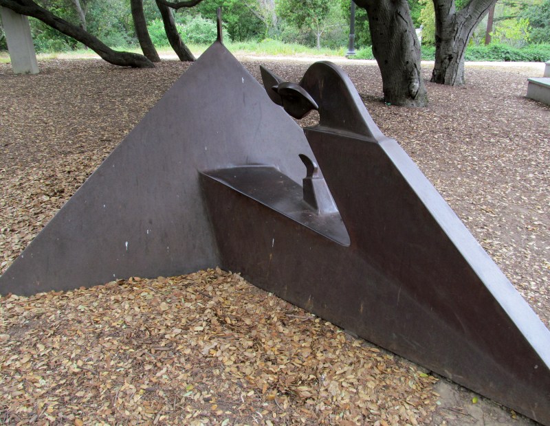 A bronze sculpture shaped like a pyramid with windows between the top and bottom. 