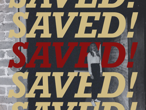 Album cover name "SAVED!" is repeated in a column of text with the middle line red and bordering mentions in a yellow hue in front of a brick wall back drop with a black-and-white cut-out of Reverend Kristin Michael Hayter standing to the right
