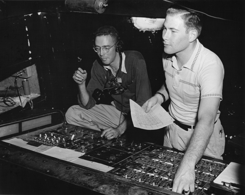 black and white photo of two male Stanford students at a light board