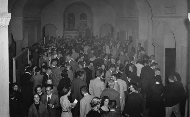 Black and white photo of Memorial Auditorium's entryway packed with students in formal attire