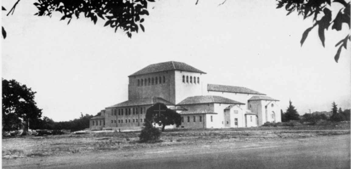 An old photo of Memorial Auditorium surrounded by greenery