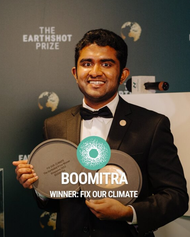 Aadith Moorthy poses with his Earthshot Prize, wearing a tuxedo.