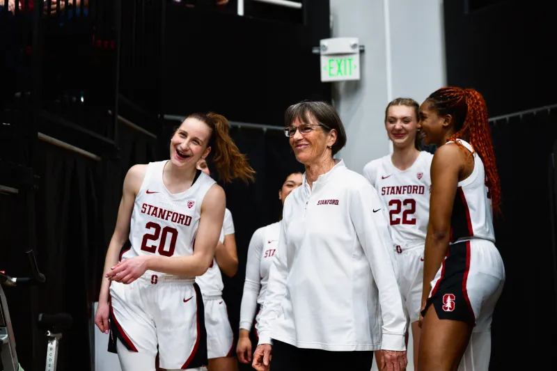 Tara VanDerveer smiles next to Stanford players
