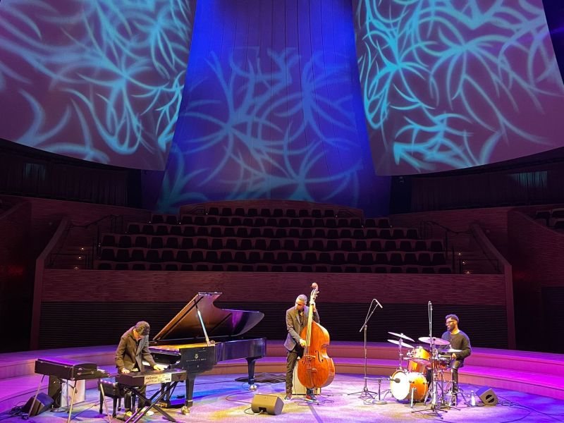 Joey Alexander on the piano being accompanied by Kris Funn on the bass, left, and John Davis on the drums, right, at Bing Concert Hall.