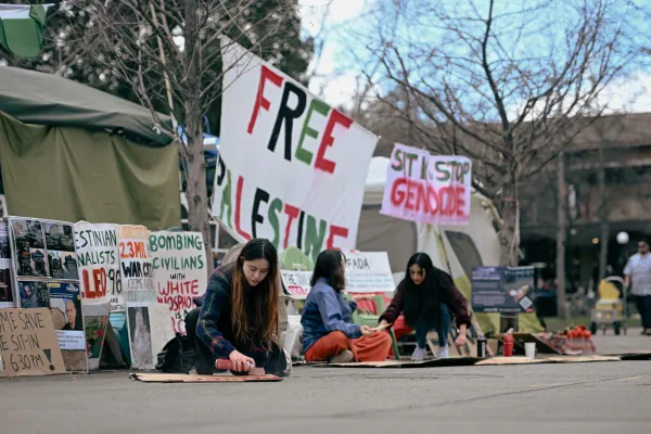 Students sit in front of a "Free Palestine" at the Sit-in to Stop Islamophobia.
