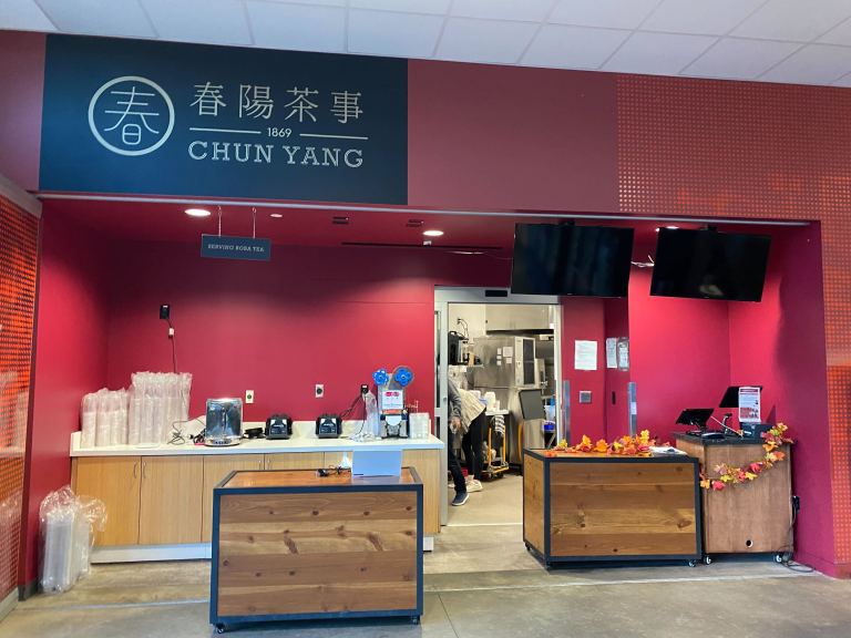 Photo of a boba tea storefront, with red walls and brown carts in the front.