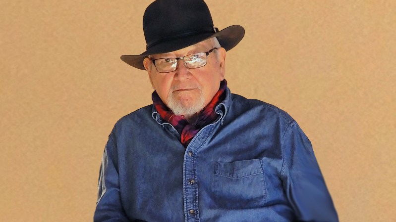 A man wearing a black hat and blue shirt.