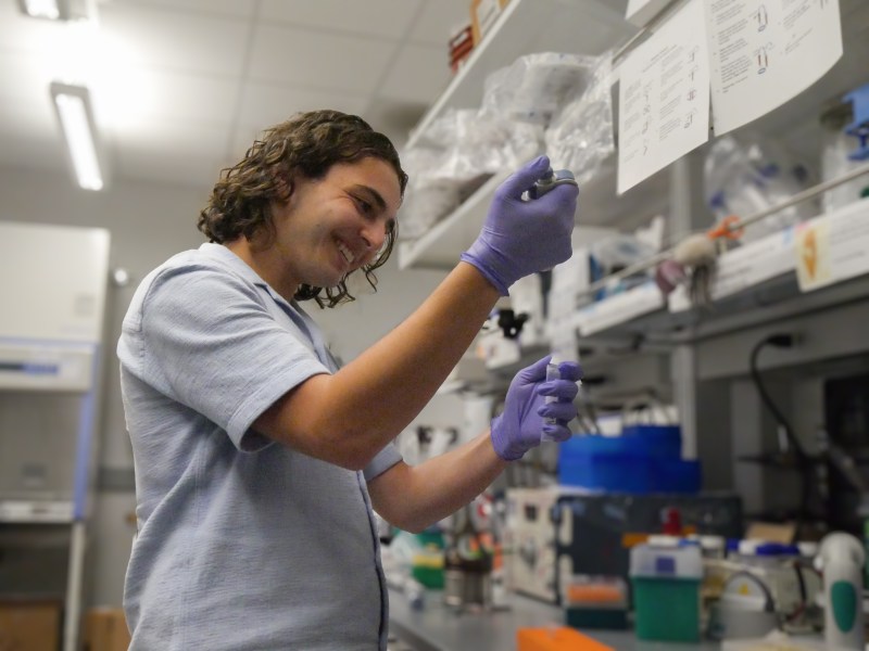 Daniel Stauber examines a vial in a bioengineering lab