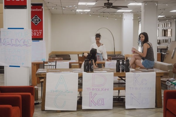 Students sit around tables with signs at Old Union.