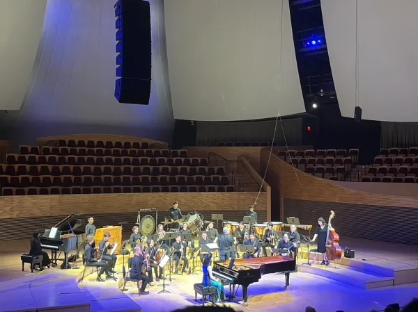 The Jazz Orchestra along with guest musicians perform at Bing under conductor Rob Kapilow and featuring piano soloist Elizabeth Schumann, bathed in blue light.