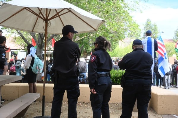 Three police watch the protest