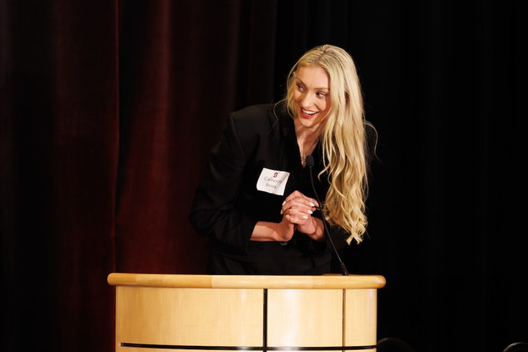 Cameron Brink leans over a podium.