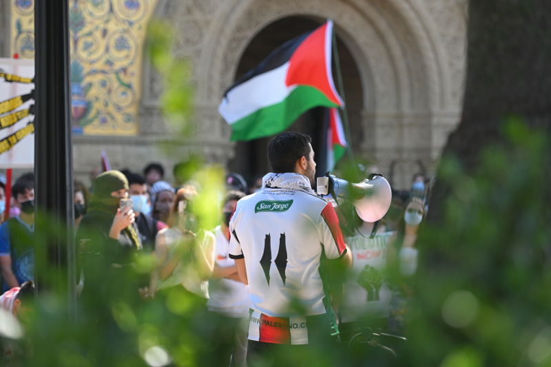 students hold a palestinian flag in front of Memorial Church