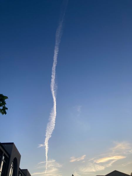A photo of the sky with a long contrail down the middle.