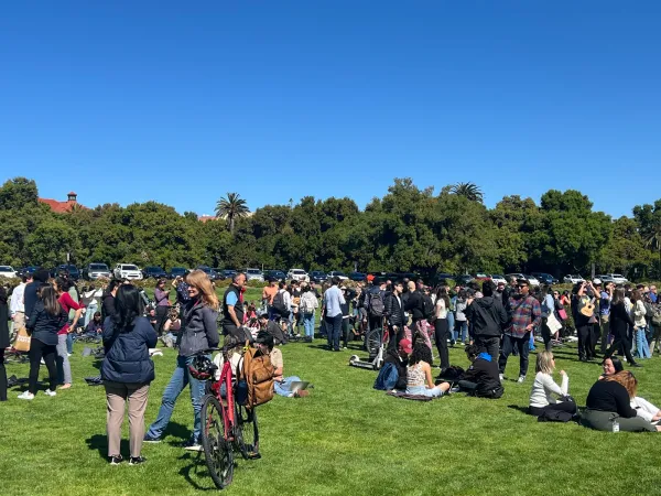 A crowd of people standing on the Oval watching the eclipse