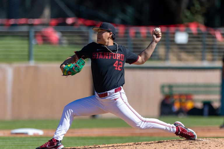 Baseball player throws pitch from the mound.