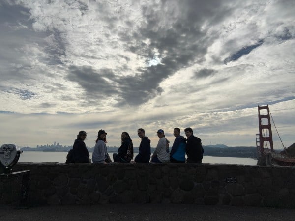 A zoomed-out image of the author's friends in front of clouds and the Golden Gate Bridge.