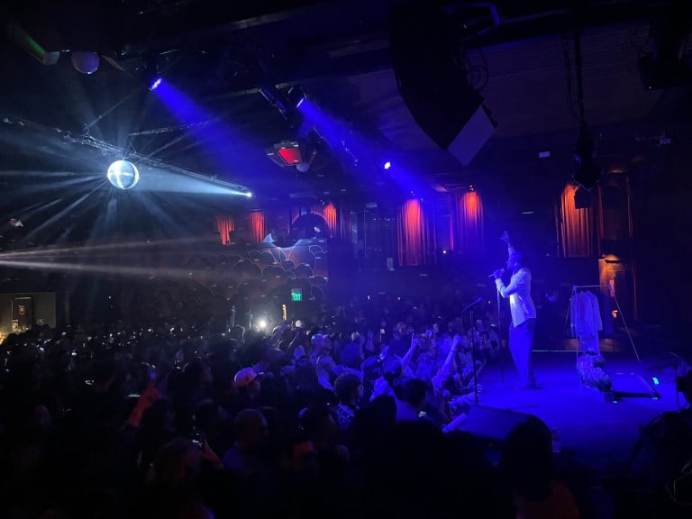 Berhana raises his pointer finger on stage, as does the densely-packed crowd. They're in a small club illuminated by a disco ball.