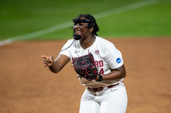 Stanford pitcher NiJaree Canady smiles and points on the field.