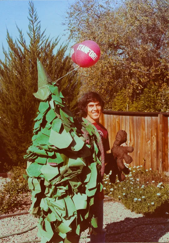 A man with a large green tree costume and a balloon that says "Stanford"