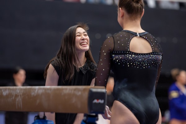 Stanford head coach Tabitha Yim greets a gymnastics player.