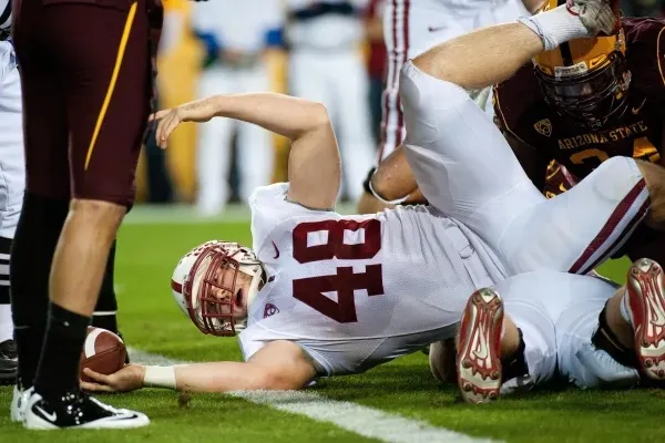 Football player lays down on the ground.