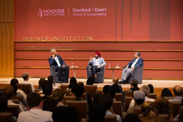 World Pank President Ajay Banga sitting onstage at the Hoover Institution with two other speakers.