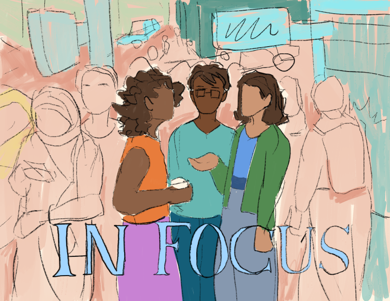 Three South Asian people stand in the middle of a crowd, with the text "In Focus" across the bottom of the image.