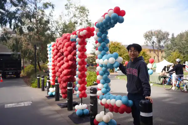 A student organizes balloons for Democracy Day at Stanford. (Photo: OSCAR WAN/The Stanford Daily)