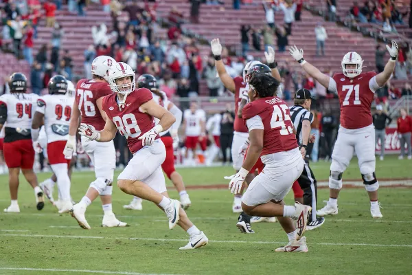 Benji Blackburn and Omar Staples celebrate on field after a game against the University of Louisville.