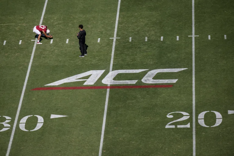 Football player on field with ACC logo.